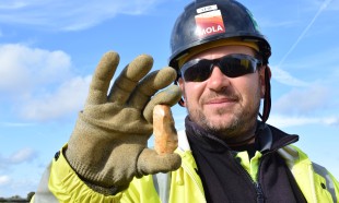 MOLA Archaeologist holding worked flint found during excavations MOLA